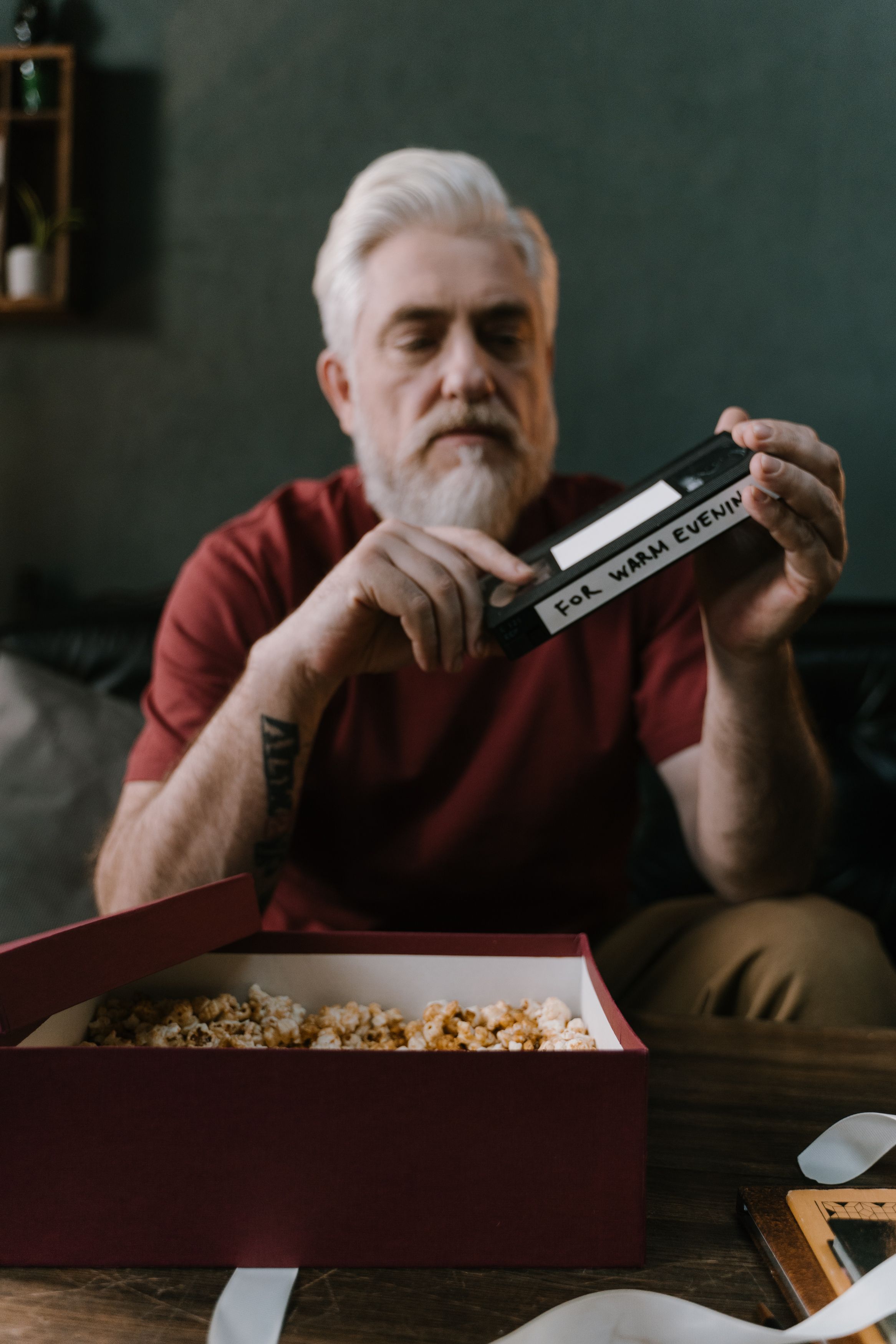 Señor con cinta VHS y palomitas